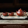 4-Piece Yixing Gongfu Tea Set including a handmade gold-sprinkled eggplant teapot, two teacups, and a bamboo-patterned tea tray from the Yixing Clay Gongfu Tea Set, presented on a rustic wooden surface