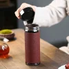 Opening the lid of a Yixing Tumbler in a tea room setting, revealing its wide mouth design for easy filling and cleaning, paired with traditional gongfu tea accessories