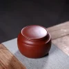 Yixing Tea Caddy placed on a linen and wooden mat, showcasing its elegant shape that matches all styles of gongfu tea sets