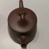 Close-up of the lid on a Yixing Purple Clay Teapot from Yixing Zisha Tea Set, featuring a bamboo-inspired handle, part of authentic Yixing Clay Tea Set