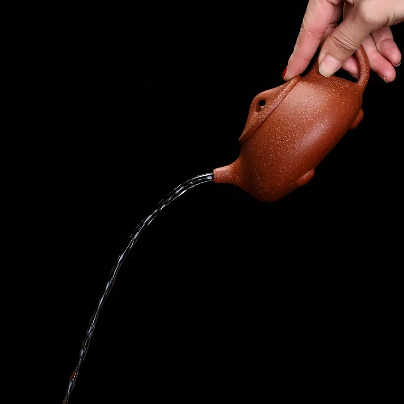 Large Purple Clay Yixing Teapot 240ML 10 A Large Purple Clay Yixing Teapot pouring a smooth stream of tea, demonstrating its excellent flow control.