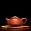 Full view of a Large Purple Clay Yixing Teapot on a bamboo mat, ready for a traditional tea ceremony.