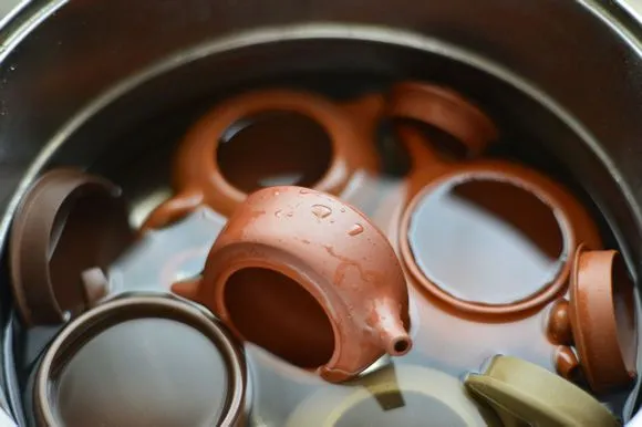 Yixing Teapot Comprehensive Guide: History And Making Methods 4 Yixing teapots being soaked in water for conditioning, an essential step in your Yixing teapot guide to proper care and preparation for tea brewing.