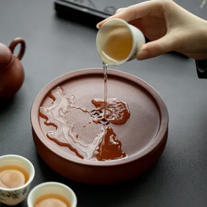 Pouring tea onto the Yixing Zhuni water storage tea tray, demonstrating the excellent water storage and drainage function for daily gongfu tea brewing