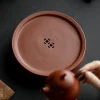 Close-up of the Yixing Zhuni water storage tea tray with coin-shaped drainage holes, highlighting the delicate craft of the round zisha tea tray