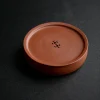 Full display of a minimalist round Yixing Zhuni water storage tea tray on a black background, perfect for home and office tea table decoration