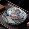 Antique Gaiwan with hand-painted goldfish patterns, part of a Best Gaiwan Tea Set, resting on a matching tray for elegant tea presentation.