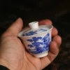 Handheld 60ml Gaiwan, a compact Small Gaiwan with blue and white landscape designs, ideal for portable tea enjoyment.