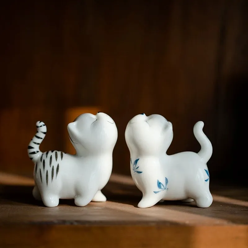 Hand-Painted Sassy Cat Ceramic Tea Pet 6 Two styles of Cat Tea Pet (blue and white & tiger stripe) under warm ambient light