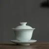Celadon Gaiwan teacup with lid and saucer, crafted from smooth celadon ceramic, displayed on a wooden table for gongfu tea brewing.