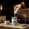 Pouring tea from a Gaiwan Teapot Set into a matching fairness pitcher, demonstrating the functional design of this Chinese Gaiwan Tea Set.
