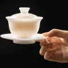 Elegant 150ml Gaiwan with lid and saucer, a premium Chinese Tea Gaiwan held gracefully, showcasing its smooth white porcelain finish.