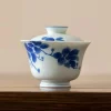 Close-up of a Dehua Gaiwan, showcasing delicate blue and white floral artwork on smooth porcelain material.