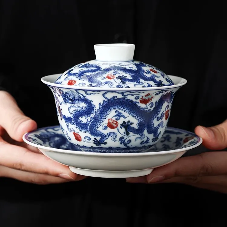 Dragon and Phoenix Auspicious Stoneware Gaiwan 165ml 1 Holding a Dragon Gaiwan with hand-painted dragon and phoenix patterns, a premium Stoneware Gaiwan tea set for traditional tea ceremonies.