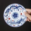 Dragon and Phoenix Auspicious Stoneware Gaiwan 165ml 16 Holding a matching saucer for a Dragon Gaiwan, featuring elaborate blue dragon and phoenix designs on durable Stoneware material.