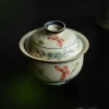 Close-up of a Gaiwan Teapot, highlighting intricate hand-painted butterfly and floral patterns on its vintage, textured ceramic surface.