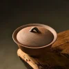 Unglazed Gaiwan with a rustic, handcrafted finish, displayed on a weathered wooden table to highlight its earthy aesthetic.