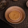 Unglazed Gaiwan tea tray with a woven rattan mat, arranged on a dark mat with other tea tools for a minimalist tea setup