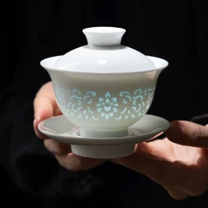 Holding a complete Rice Pattern Gaiwan, showcasing its translucent floral motifs and premium porcelain craftsmanship.