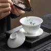 Adding tea leaves to a Porcelain Gaiwan, capturing the traditional tea preparation process with this elegant rice pattern gaiwan.