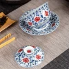 Glazed Porcelain Gaiwan with lid separated, showcasing intricate blue and red floral patterns on a traditional tea mat.