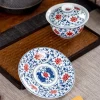 Glazed Porcelain Gaiwan and saucer separated, displaying detailed blue-red lotus motifs on a bamboo tea tray.