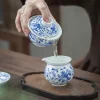 Jingdezhen Gaiwan being used to pour tea into a matching blue and white porcelain pitcher during a Gongfu tea ceremony