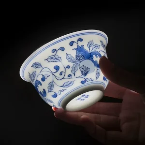Jingdezhen Porcelain Gaiwan bowl held in hand, showcasing delicate blue and white hand-painted patterns and the maker’s mark on the base