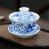 Complete Jingdezhen Gaiwan set with blue and white pomegranate patterns, placed on a woven tea tray for traditional tea preparation