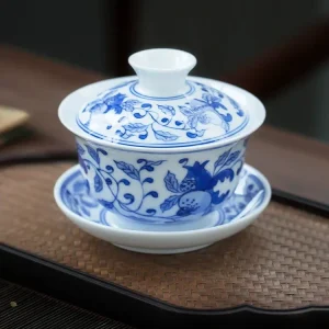 Complete Jingdezhen Gaiwan set with blue and white pomegranate patterns, placed on a woven tea tray for traditional tea preparation