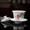 Red Blossom Gaiwan with lid removed, resting on a reflective black surface to highlight its translucent porcelain and hand-painted plum blossom design