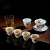 Complete Mei Leaf Gaiwan tea set with matching red blossom teacups, arranged on a dark mat for a refined tea ceremony experience