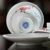 Bottom view of a Mei Leaf Gaiwan, displaying the Jingdezhen maker’s mark and the continuation of red blossom patterns on its base