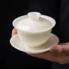 Holding a complete Mutton Fat Jade Gaiwan, highlighting its translucent white porcelain and delicate relief landscape motifs on the gaiwan tea bowl.