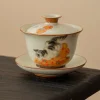 Complete Cat Gaiwan with lid, featuring hand-painted cat and persimmon motifs, resting on a wooden table for an elegant tea presentation.