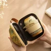 Travel Gaiwan tea set neatly packed inside its compact travel bag, held in a hand to demonstrate its portability for outdoor and travel tea ceremonies.