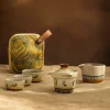 Travel Gaiwan tea set arranged on a linen surface, with the vibrant travel bag beside it, highlighting the set's artistic design and suitability for travel and gifting.