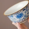 Traditional Blue and White Ru Kiln Gaiwan Tea Set 140 ml 18 Close-up of the bowl of a Ruyao Gaiwan, part of a Traditional Gaiwan Tea Set, showcasing intricate blue floral underglaze patterns and a delicate golden rim.