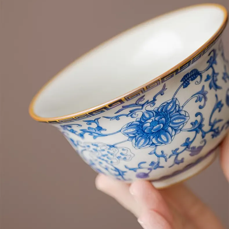 Traditional Blue and White Ru Kiln Gaiwan Tea Set 140 ml 9 Close-up of the bowl of a Ruyao Gaiwan, part of a Traditional Gaiwan Tea Set, showcasing intricate blue floral underglaze patterns and a delicate golden rim.