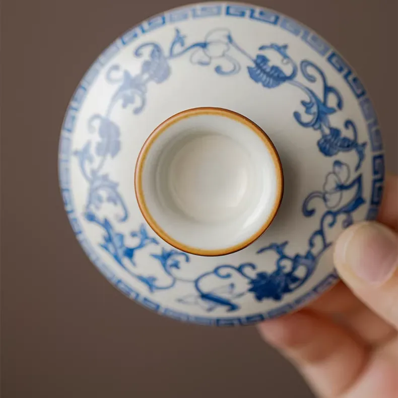 Traditional Blue and White Ru Kiln Gaiwan Tea Set 140 ml 10 Close-up of the lid of a Ruyao Gaiwan, a key component of a Traditional Gaiwan Tea Set, featuring matching blue floral underglaze motifs and a warm brown rim.