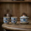Traditional Blue and White Ru Kiln Gaiwan Tea Set 140 ml 16 Traditional Gaiwan Tea Set with 4 teacups, showcasing the detailed blue underglaze patterns on this elegant Ruyao Gaiwan against a warm wooden backdrop.