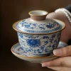Traditional Blue and White Ru Kiln Gaiwan Tea Set 140 ml 14 Holding a complete Ruyao Gaiwan from a Traditional Gaiwan Tea Set, highlighting its delicate blue floral patterns and classic three-piece design.