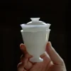 Mini Gaiwan, 50ml Gaiwan: Handheld white porcelain gaiwan with footed base, showcasing delicate craftsmanship in a dark setting