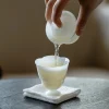 Mini Gaiwan, 50ml Gaiwan: Pouring tea from white porcelain gaiwan into matching teacup, demonstrating traditional tea preparation