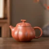 A complete Yixing Pumpkin Teapot, crafted from authentic Yixing Purple Sand clay, displayed on a wooden table.