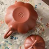 The bottom of a Yixing Pumpkin Teapot, featuring the artisan's seal stamp, a mark of authentic Yixing Purple Sand craftsmanship.