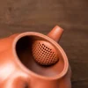 Close-up of the built-in tea strainer inside a Yixing Pumpkin Teapot, designed for efficient tea leaf filtration.