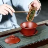 Adding tea leaves to Yixing Purple Clay Gaiwan with a tea scoop for Gongfu tea preparation
